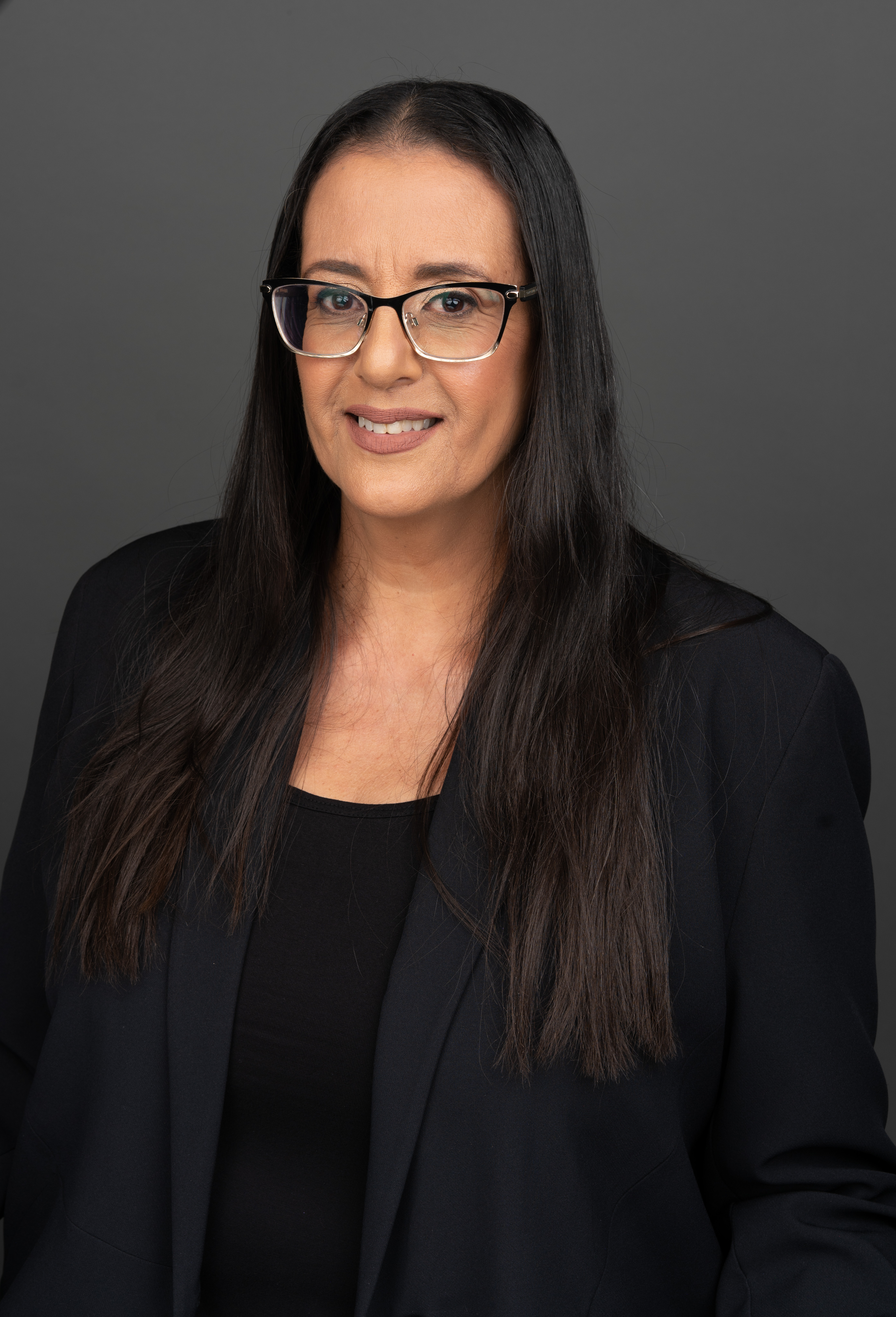 מצולמת לובשת בגדים שחורים על רקע אפור