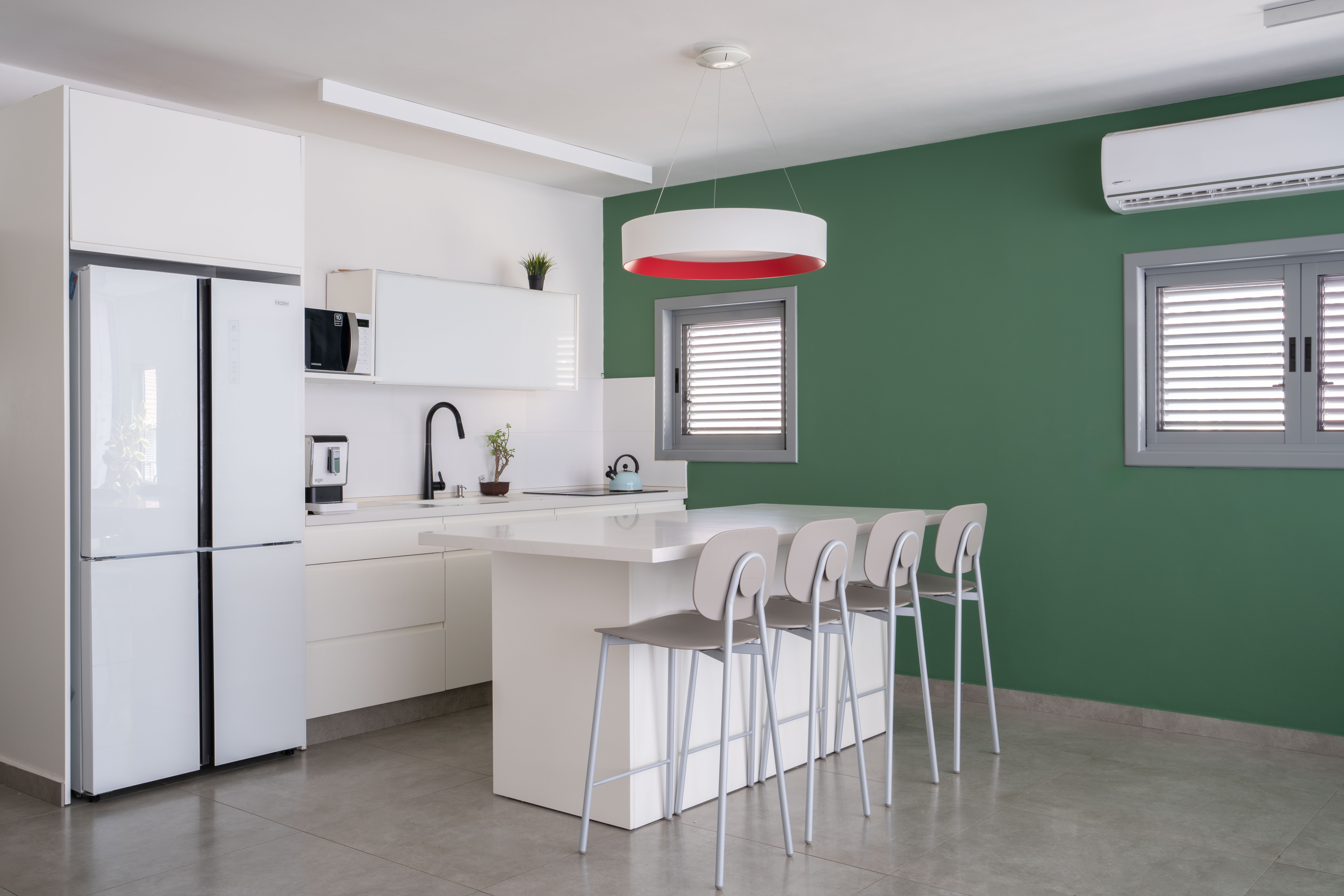 מטבח בגוונים בהירים לבנים וקיר ירוק