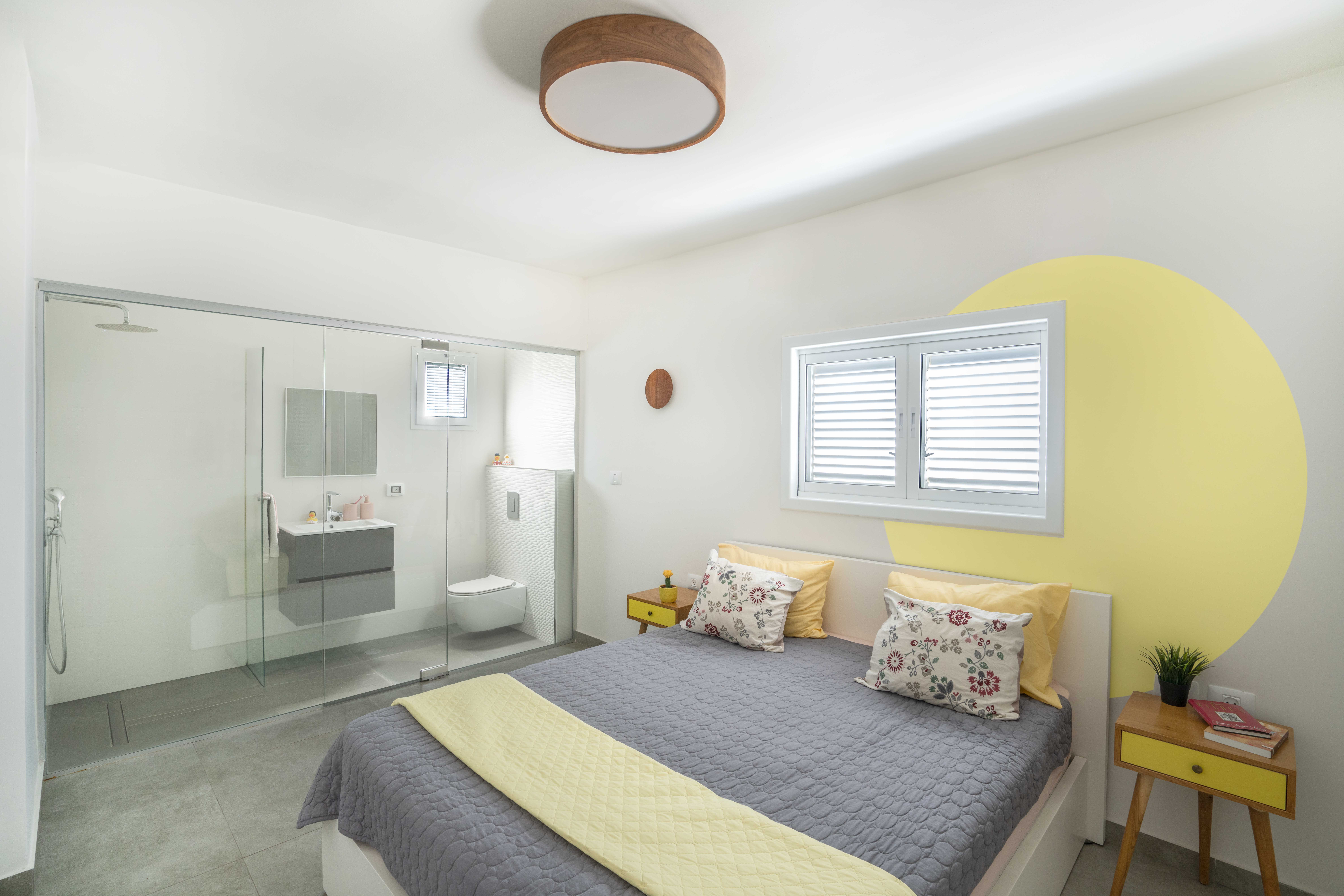 מיטה בחדר שינה ומקלחת ברקע