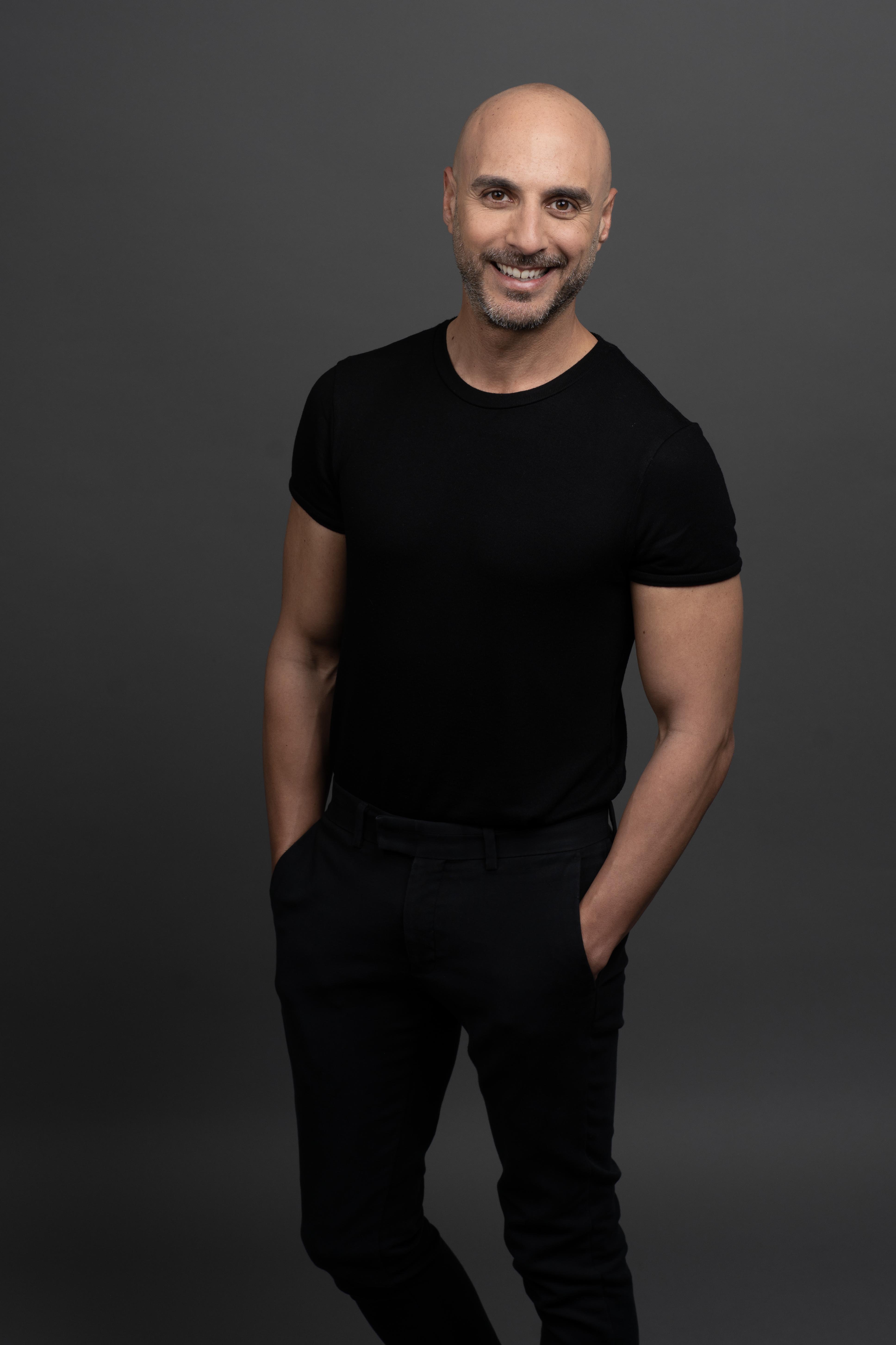 תמונת תדמית של בחור עם בגדים כהים וידיים בכיסים